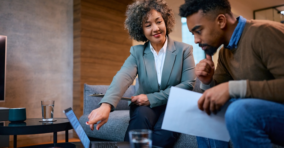 financial consultant and her client using laptop during meeting