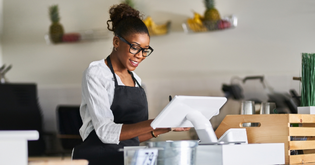 shop assistant using pos terminal to input orders