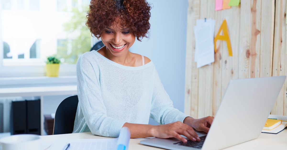 young woman working at desk with her laptop