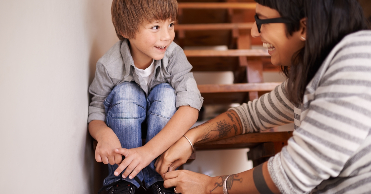 mother teaching her son to tie shoes