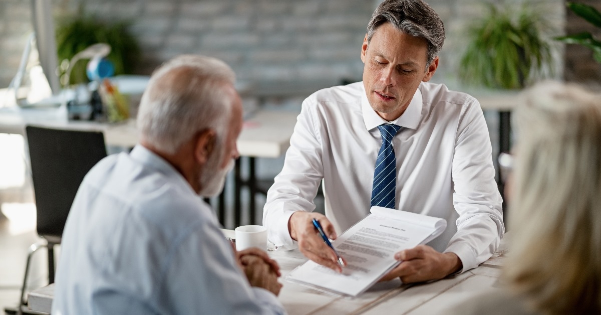 insurance agent and senior couple analyzing terms of a contract in their meeting in the office of insurance company