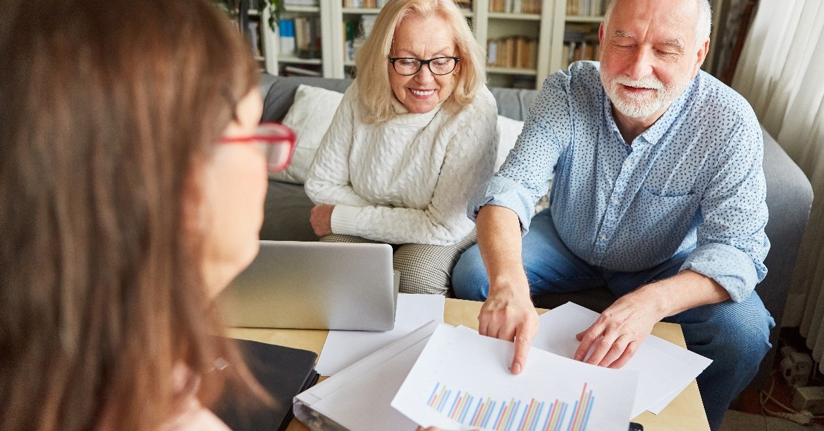 senior couple discussing financial documents with their advisor while sitting in her office