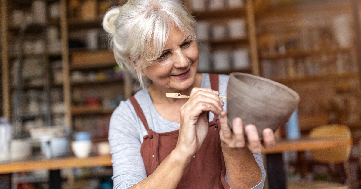 senior woman making ceramics from clay