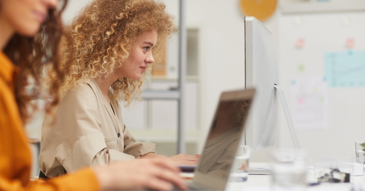 young women sitting at office working on laptops