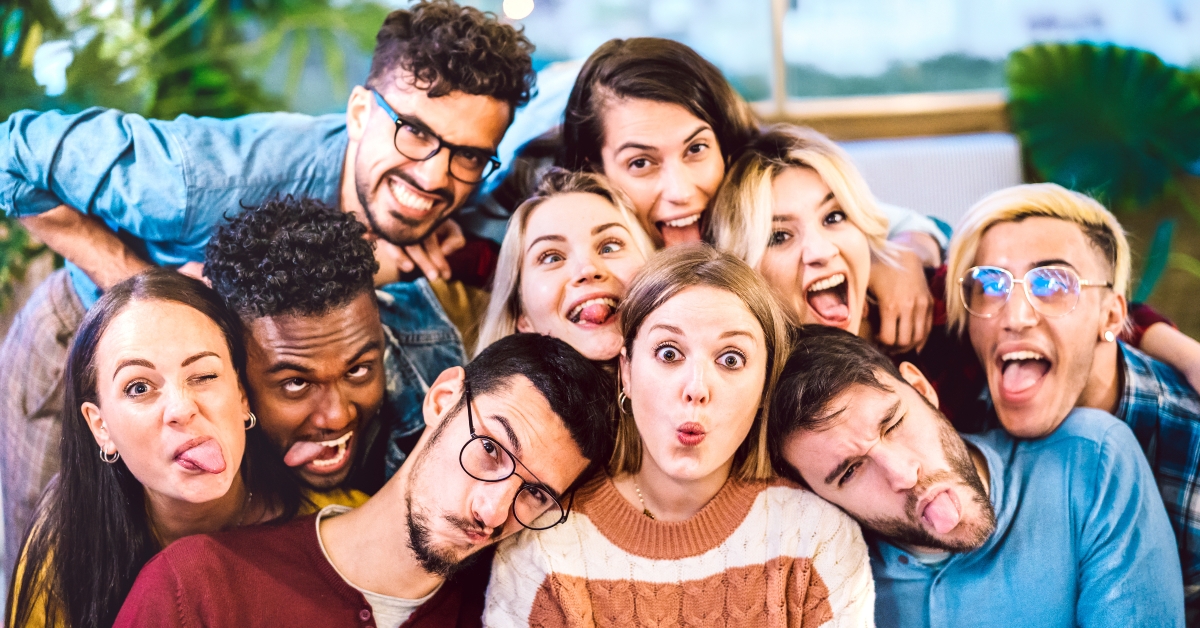 men and women taking selfie sticking out tongue