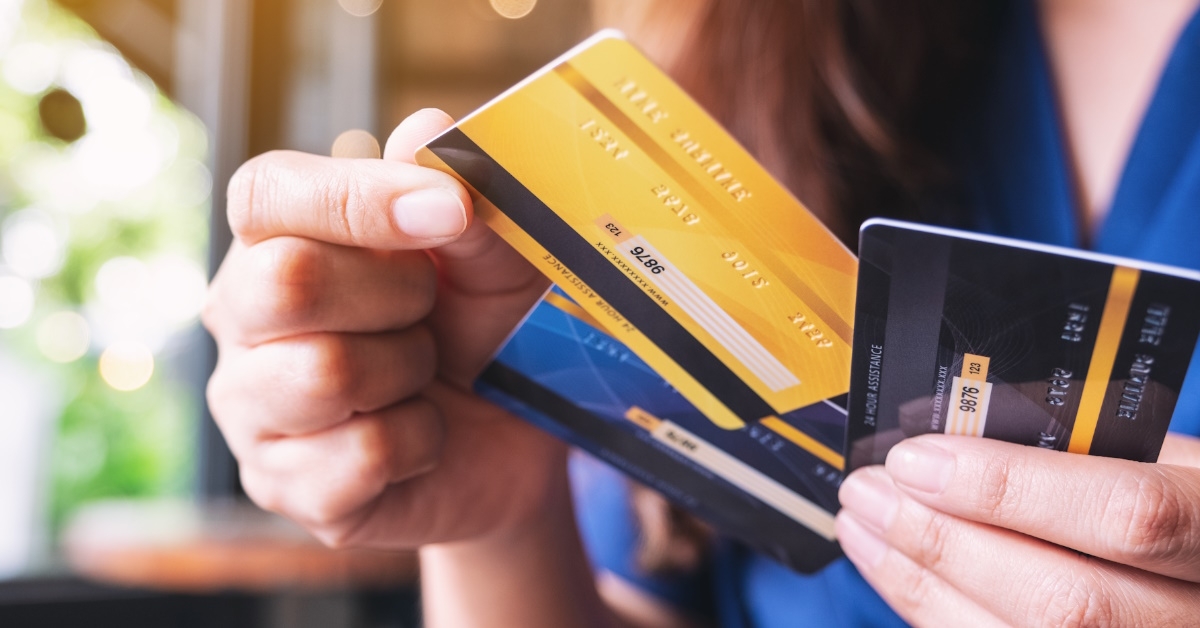 woman holding various cards in hand choosing one for payment