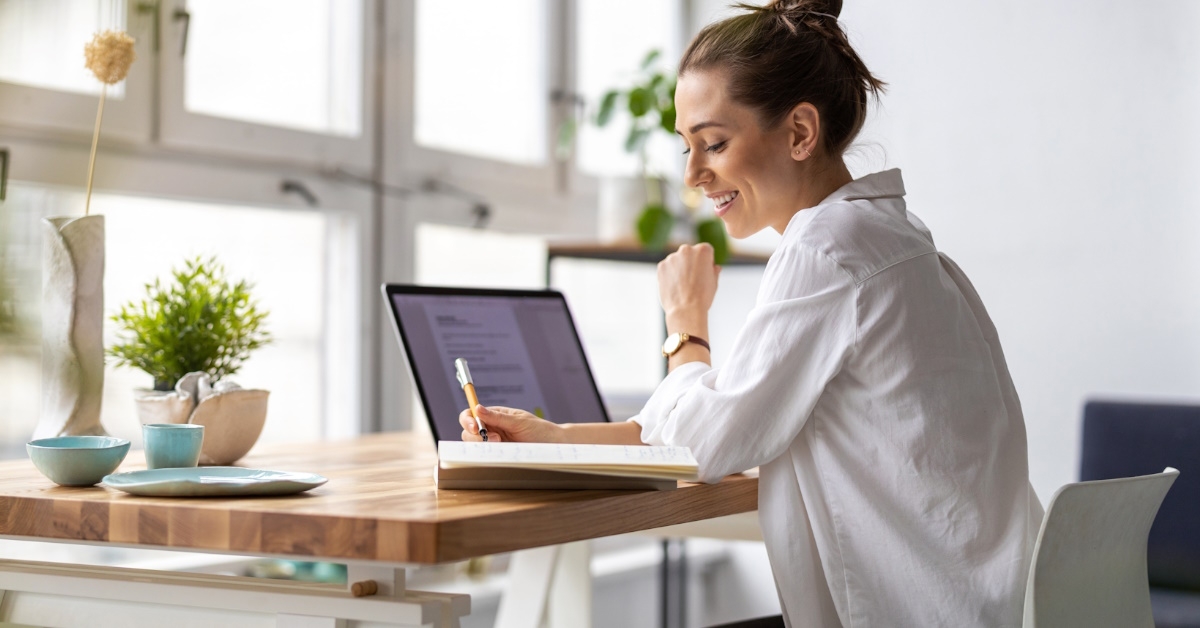 young woman sitting in her personal studio using laptop during day time