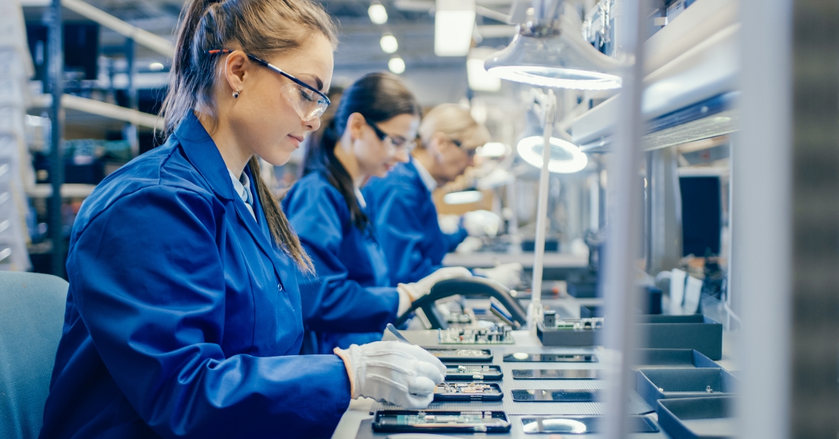 female electronics factory workers in blue work coat