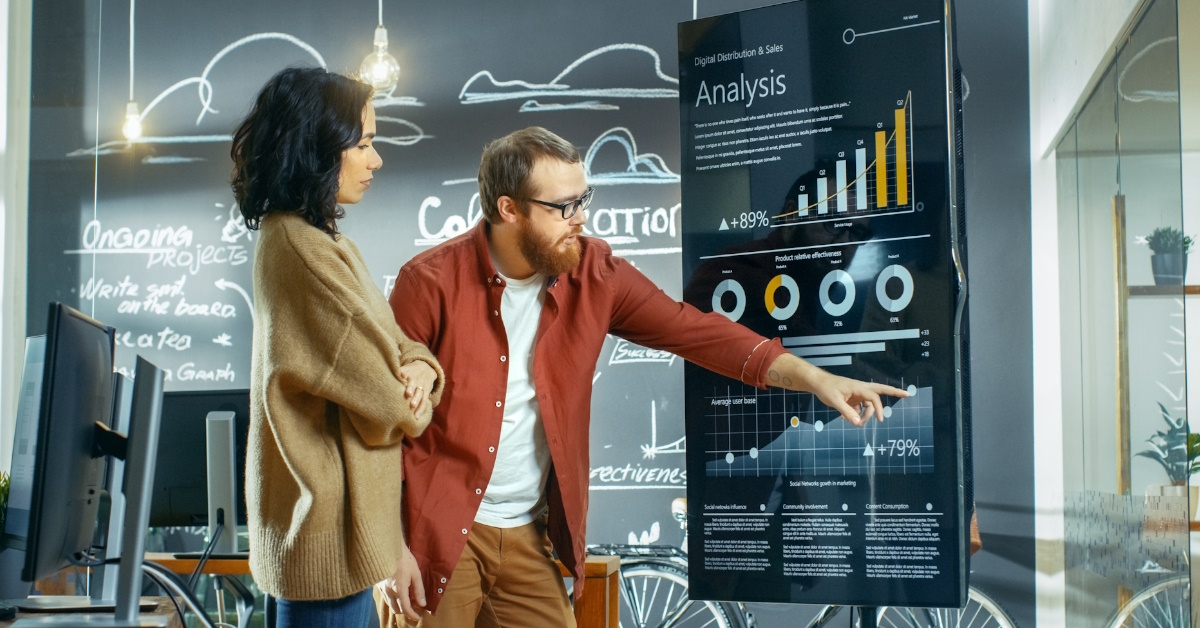 male statistician using graph to explain data to female developer 