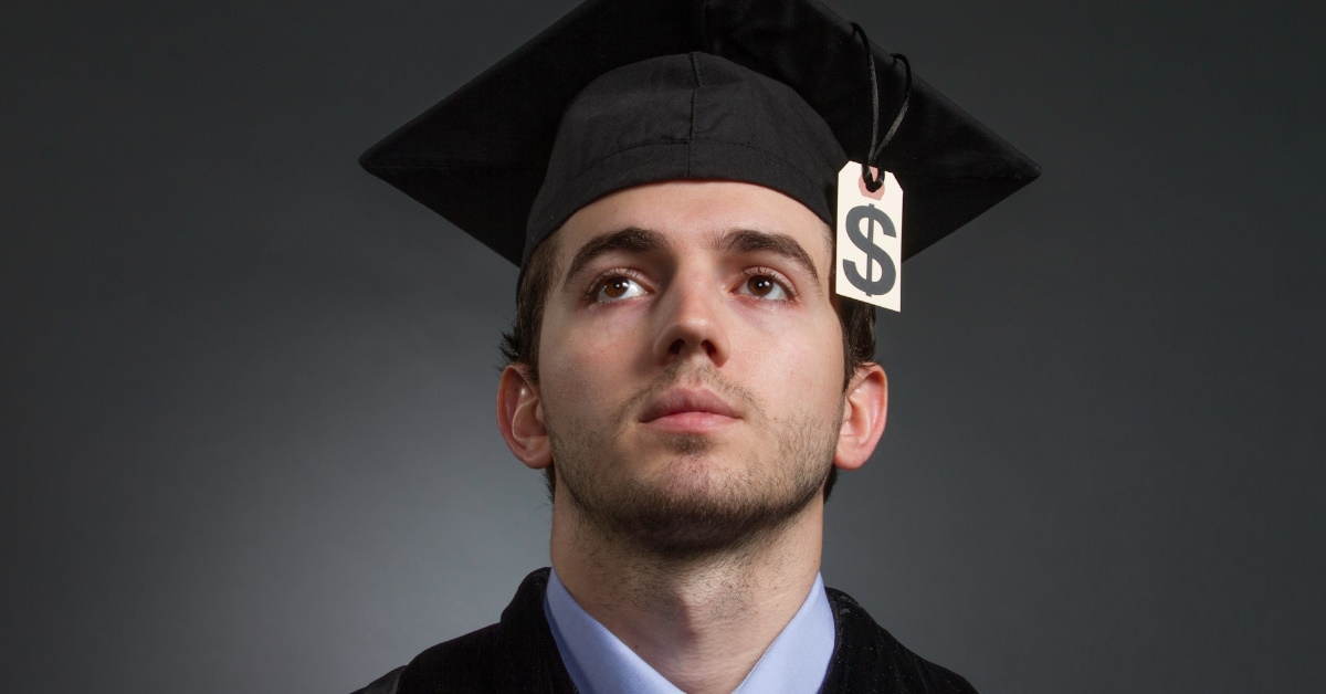 man wearing graduation hat with dollar sign showing concept of college graduate with large tuition bill