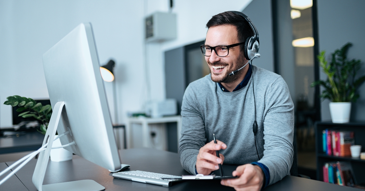 smiling businessman using headset when talking to customer
