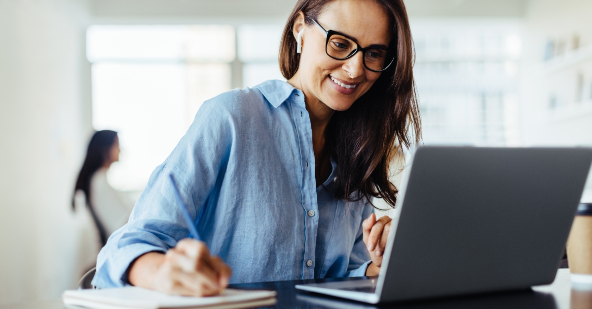 woman making notes during an online business meeting