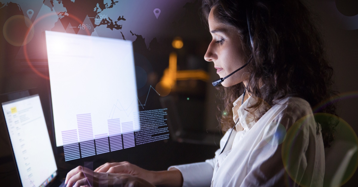 female call centre operator using desktop computer for work late at night