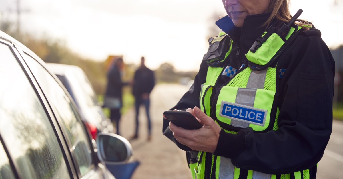 female traffic police officer recording details of road traffic accident