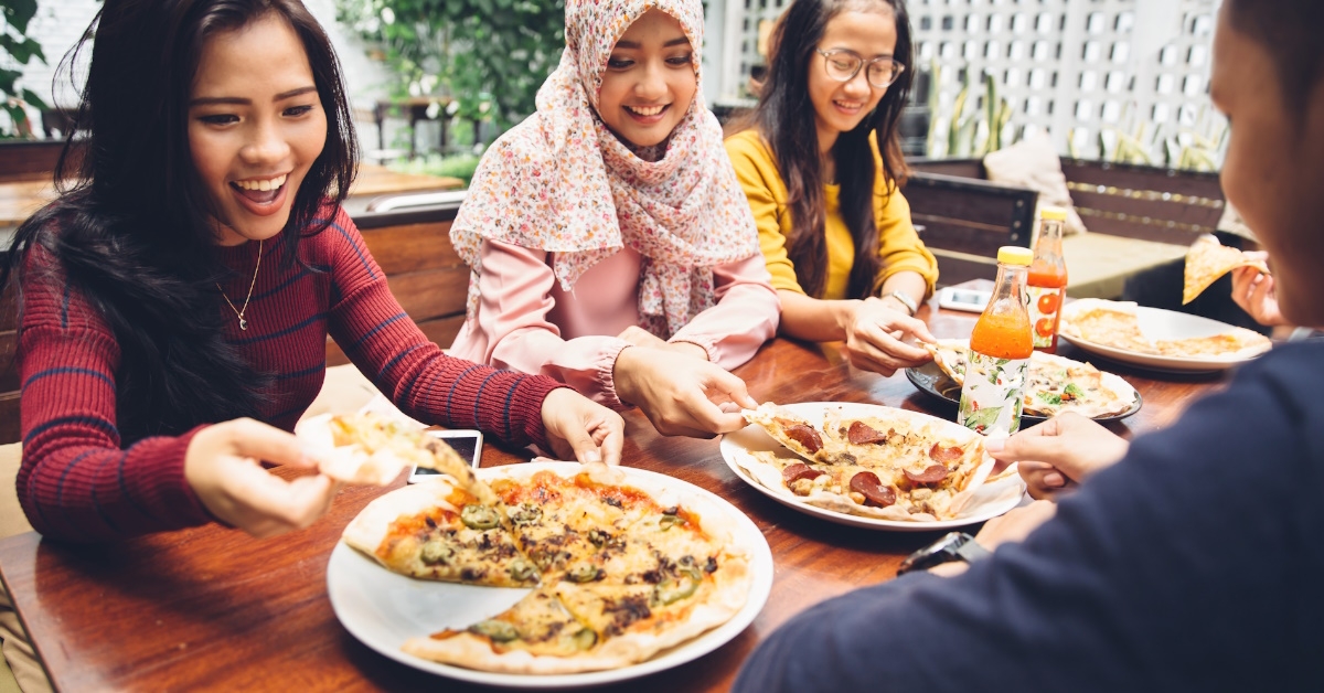 friends eating pizza in a restaurant