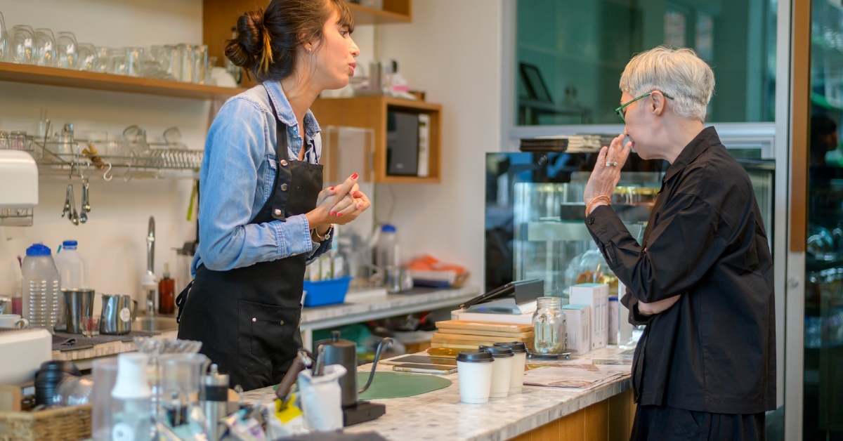senior client standing in cafe complaining to female waitress