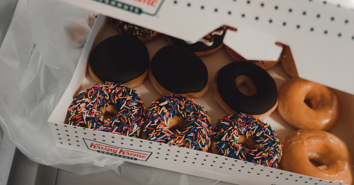 Close up of Krispy Kreme donuts with chocolate glaze and colorful sprinkles.