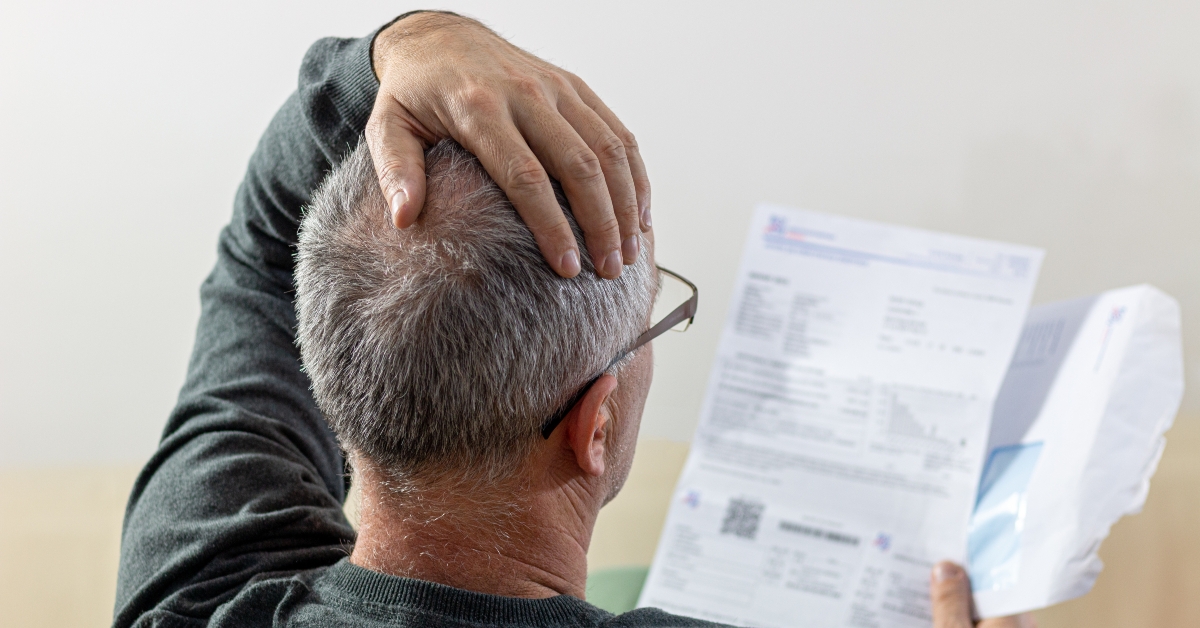 middle-aged man reading unexpected news in paper document