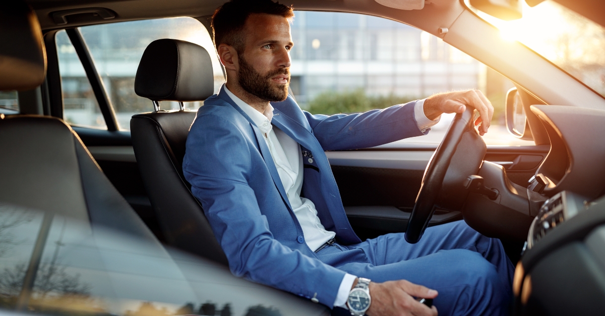 attractive man in business suit driving car