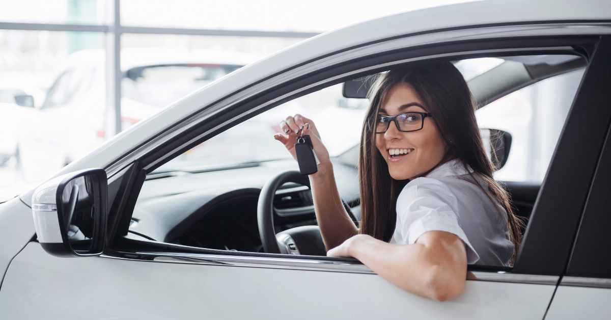 happy woman near the car with keys in hand