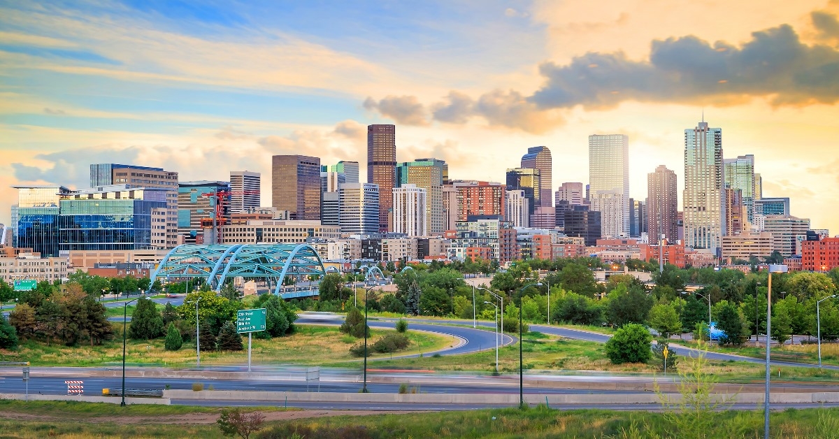beautiful paranoma view of Denver with tall buildings, curvy roads and sky just before sunset
