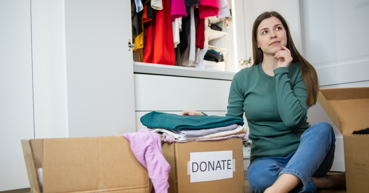 woman sits on the floor next to cardboard boxes