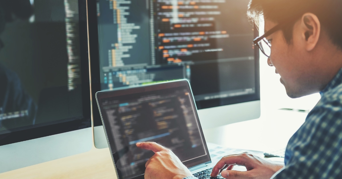 A programmer is developing and designing a website using coding technologies in a software company office.