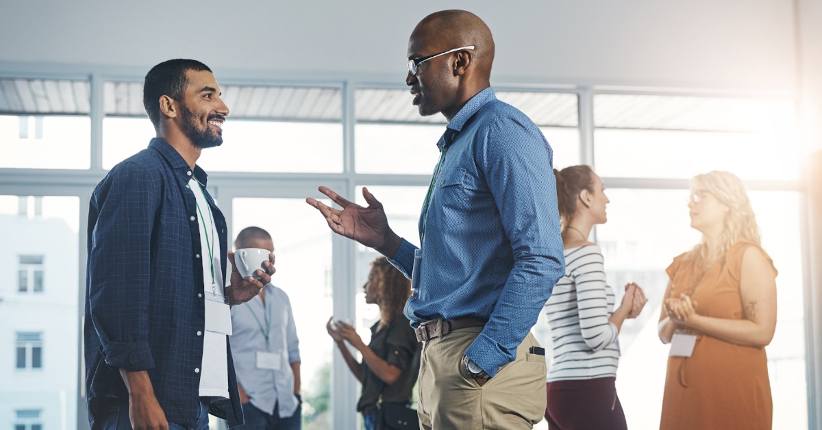 A group of people from diverse backgrounds, meeting and sharing their thoughts on new innovations during a business conference held in an office.