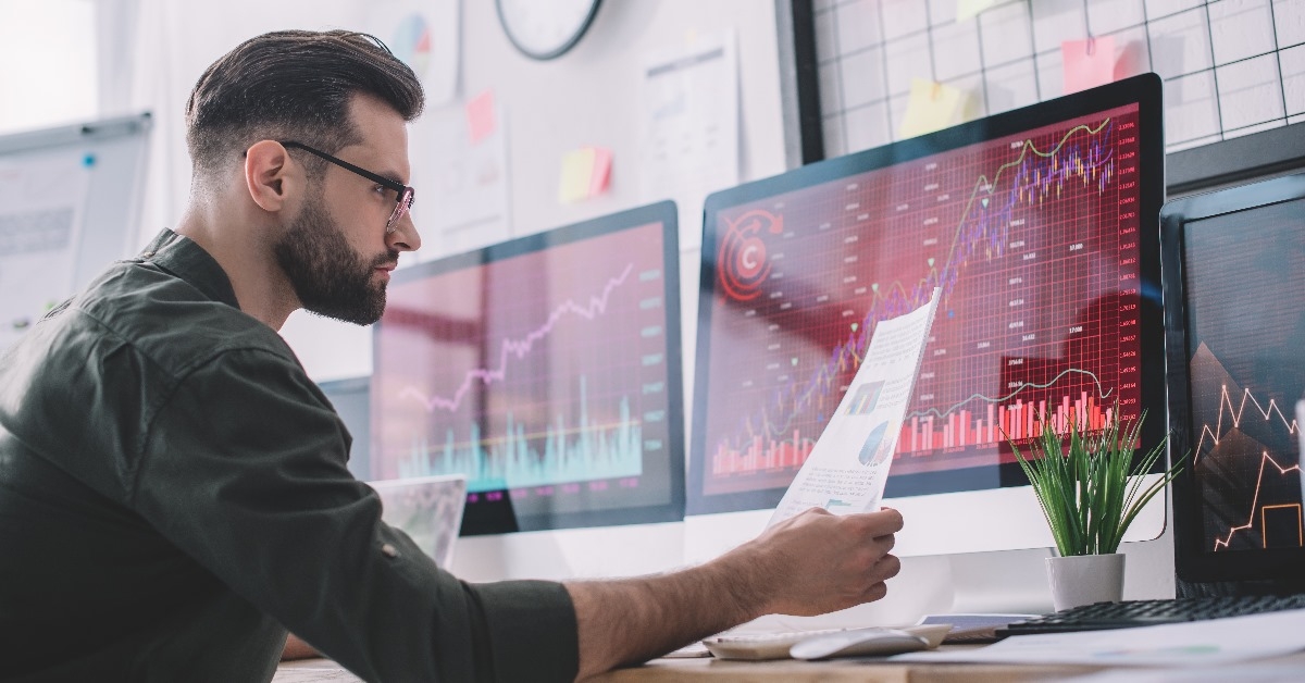 information security analyst looking at graphs on computer screen