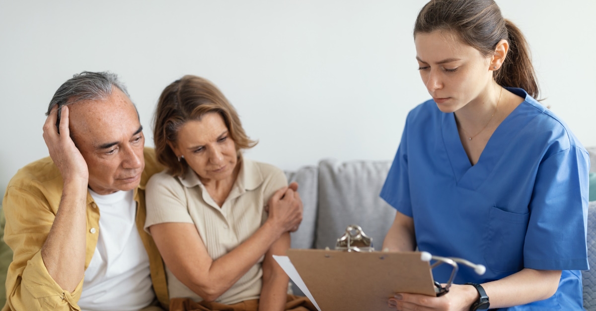 sad senior couple getting diagnosis from young female doctor in clinic