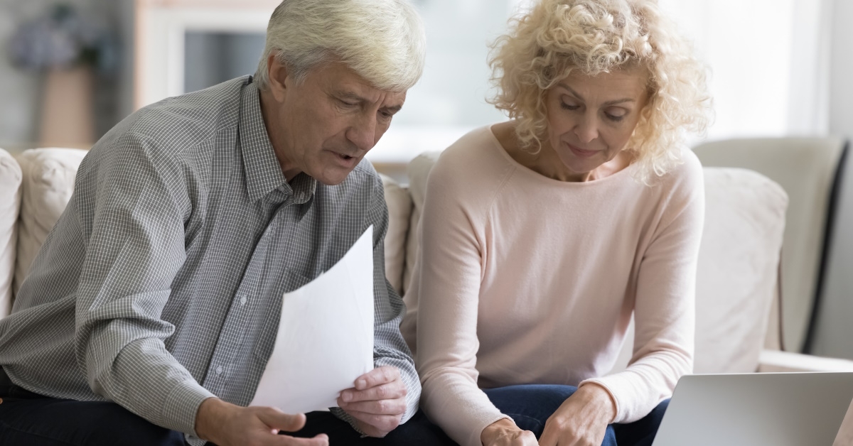 A retired married couple looking at a budget