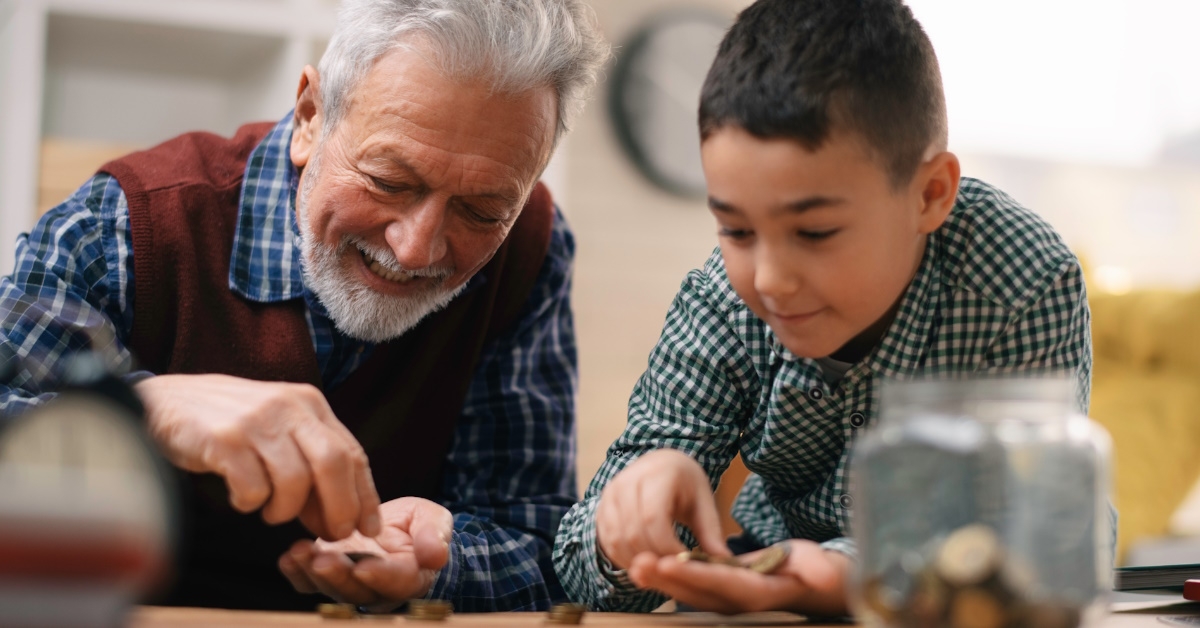 grandson and grandpa sitting on floor counties pennies while playing