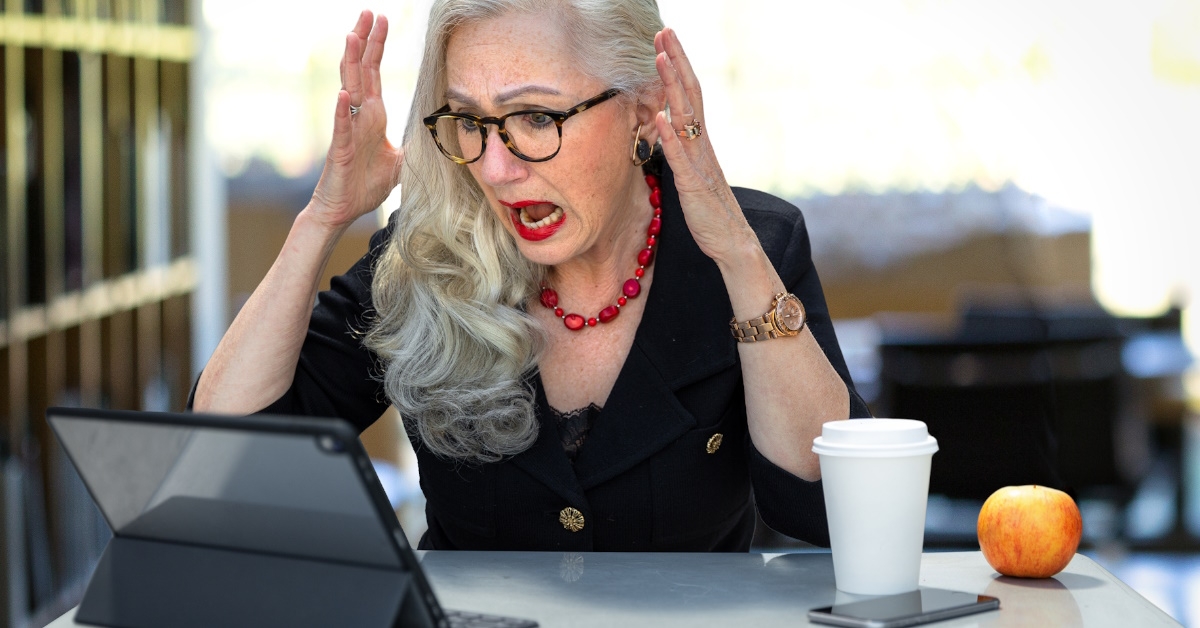 senior businesswoman at work screaming at tablet in office