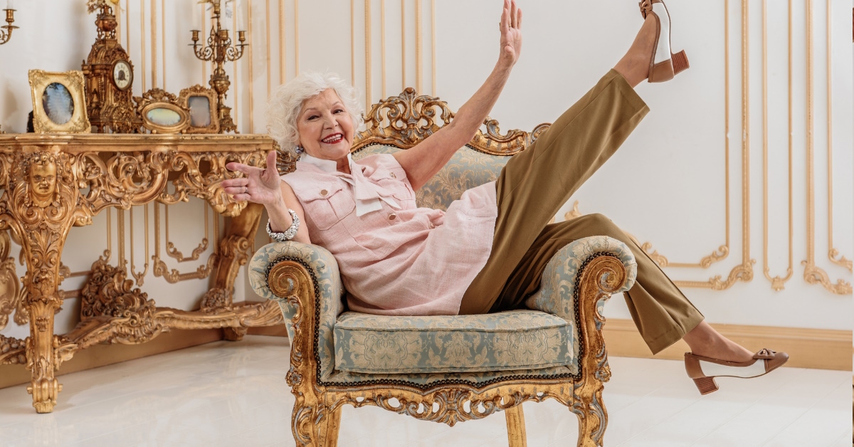 happy senior woman sitting in sofa chair enjoying at luxurious home after retirement