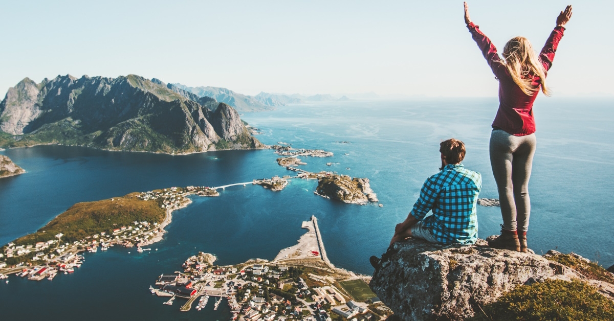 couple sitting on top of mountain on vacation