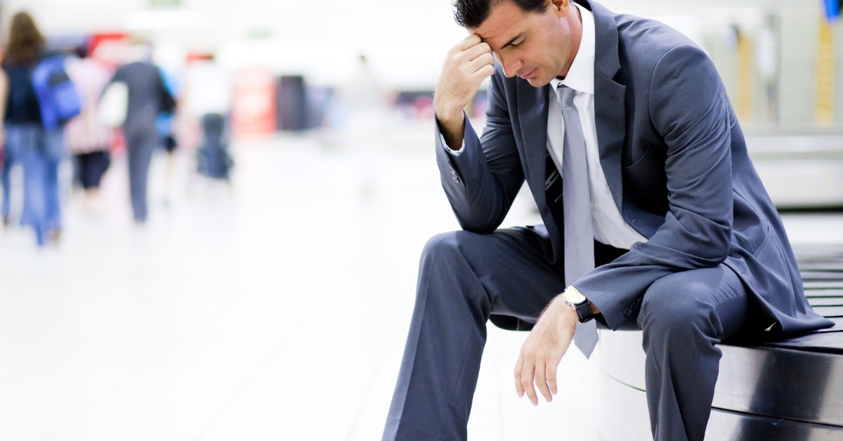stressed businessman sitting at airport