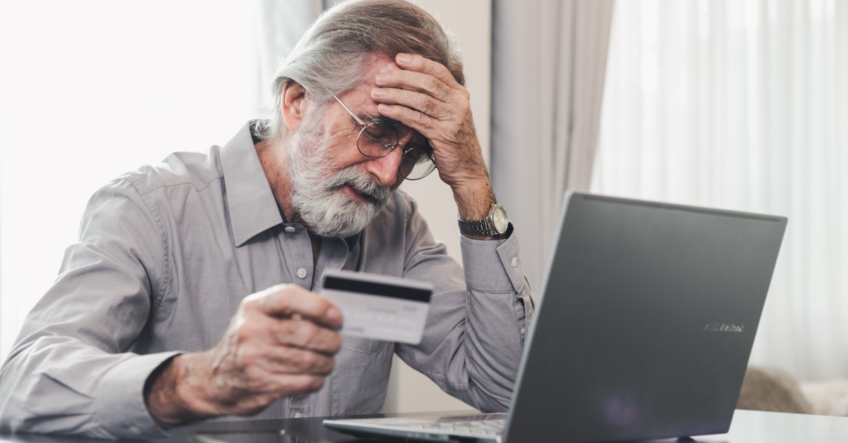 senior man stressing while using laptop