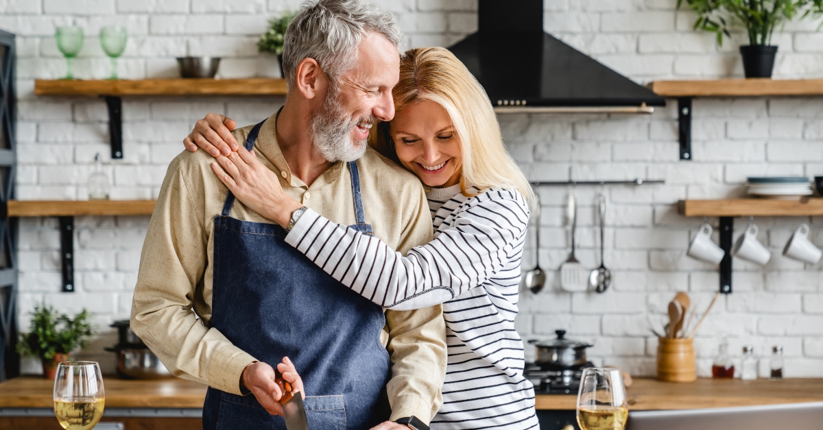 mature couple hugging while cooking