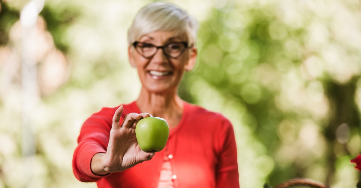 senior woman holding apple