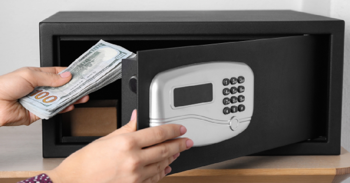 woman putting money into steel safe