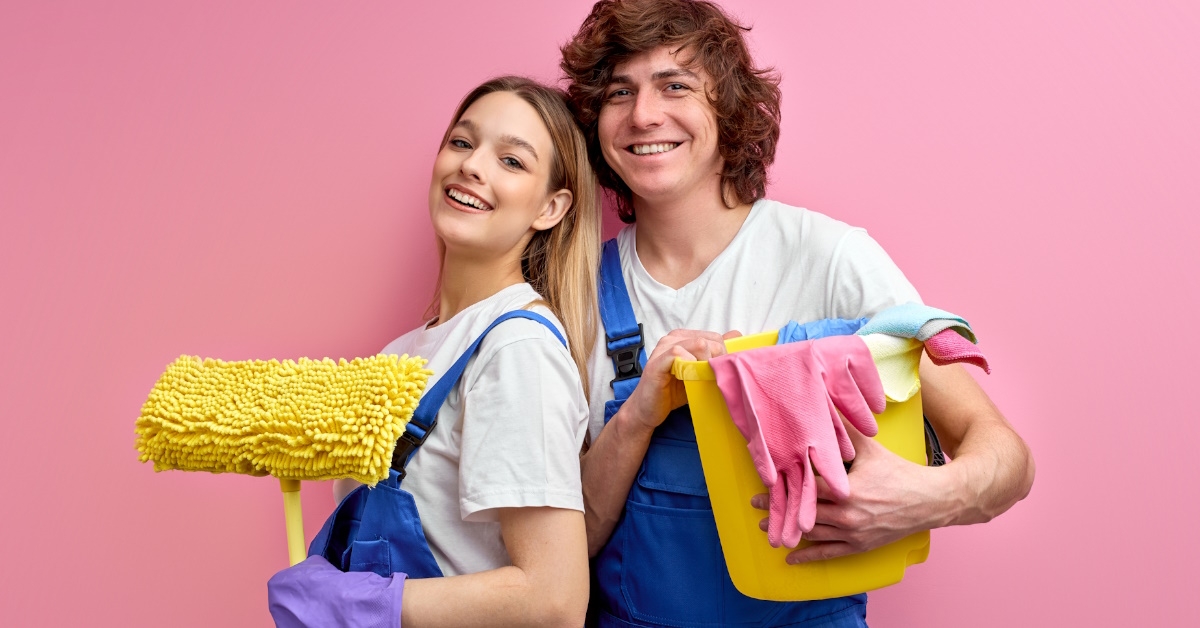 couple standing with cleaning tools