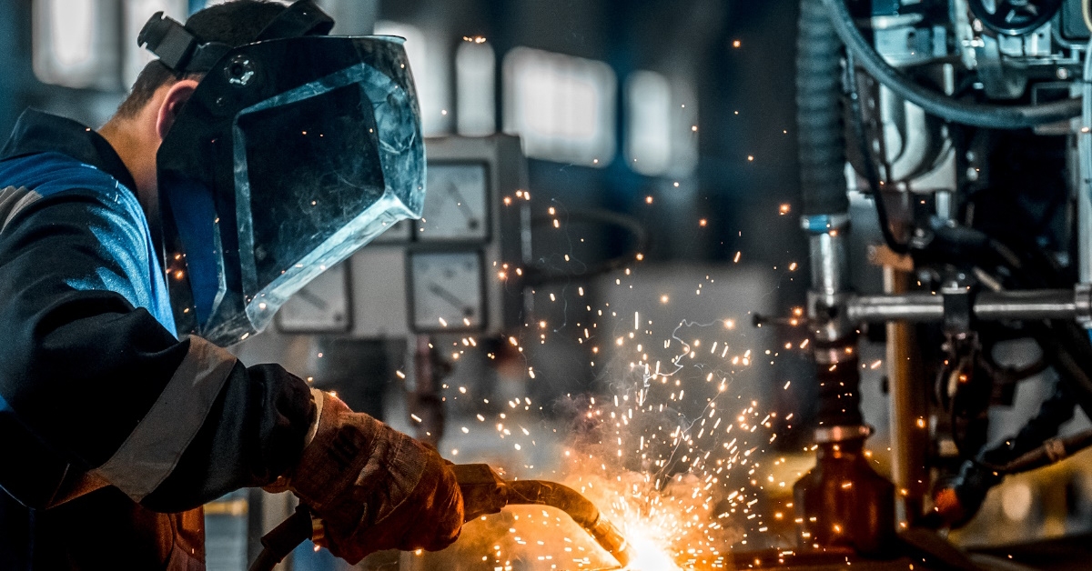 worker engaged in welding in factory.