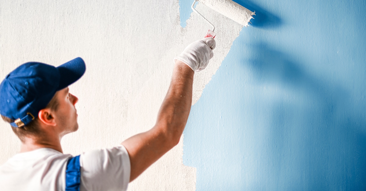 painter coating wall with fresh paint.