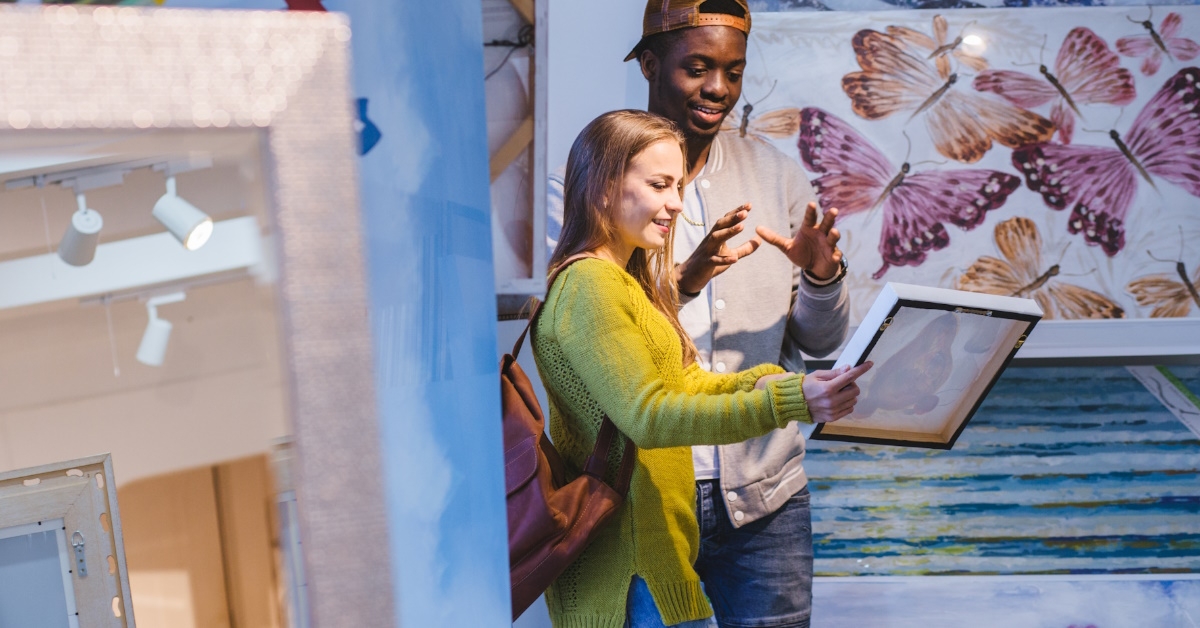 happy couple choosing art at gallery