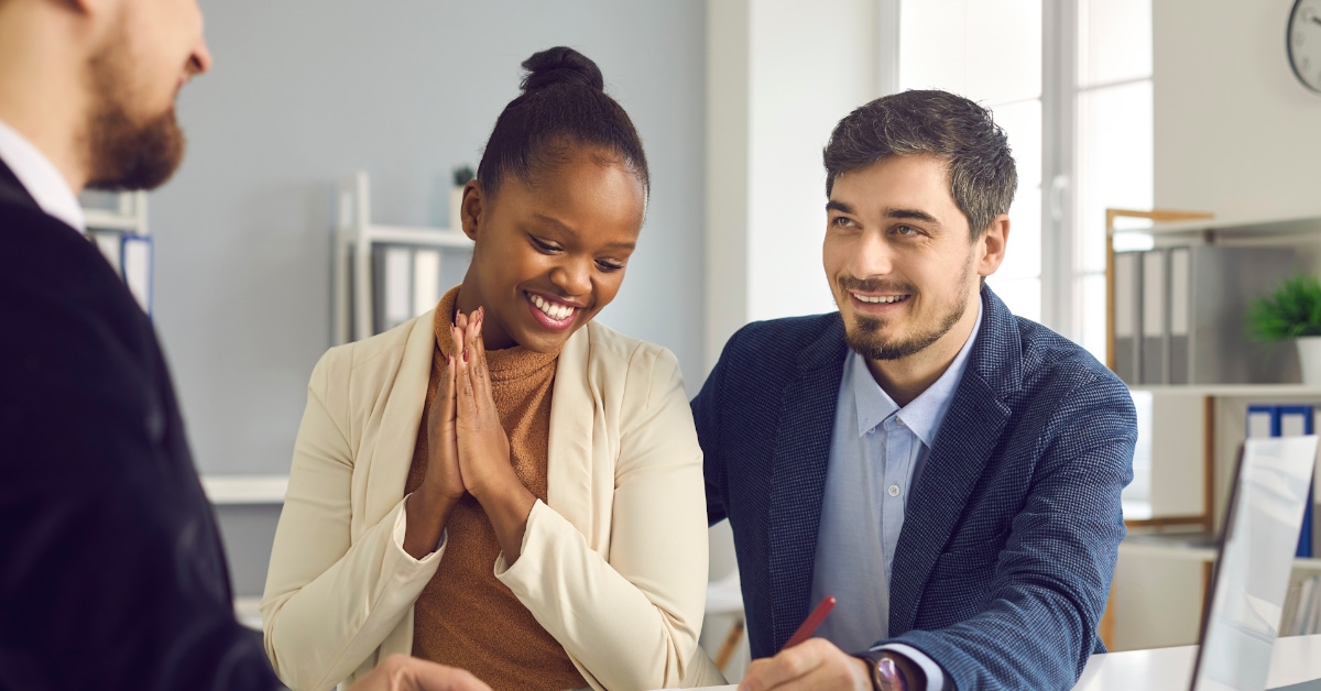 happy couple signing mortgage documents