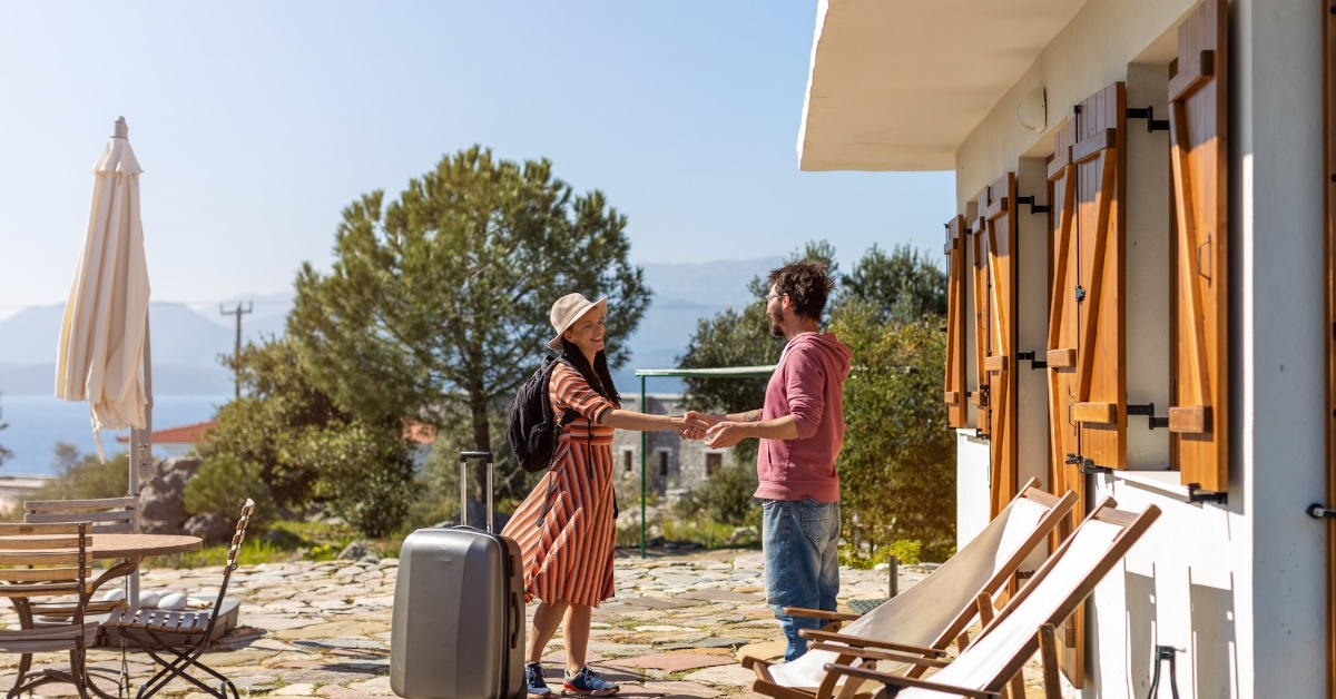 host welcoming guest at rental house