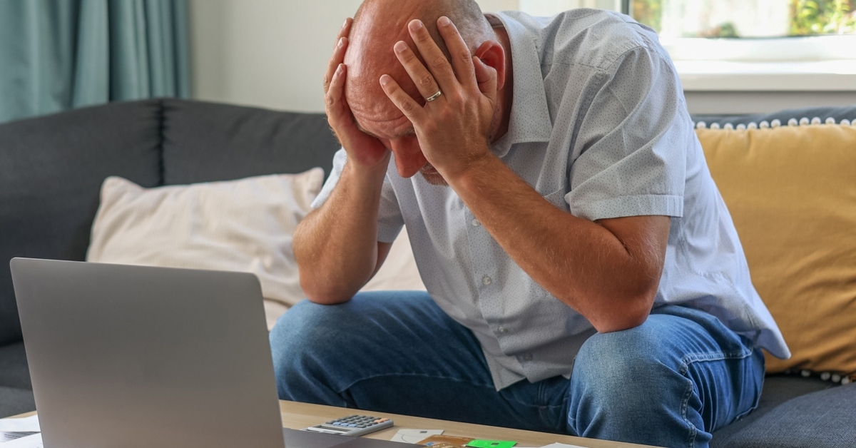 Man sitting with laptop stressed
