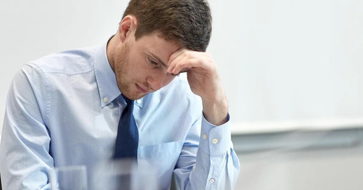 businessman with his head lowered, facing challenges.