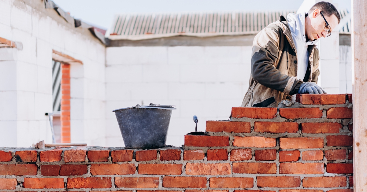 man building brick wall