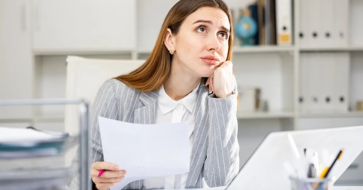 office worker lost in thought as she gazes upward.